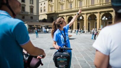 The tour guide points out something of interest while on a Segway in Florence, Italy