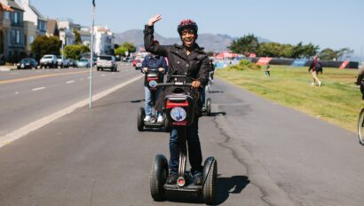 A woman waves as she rides a Segway in San Francisco, California