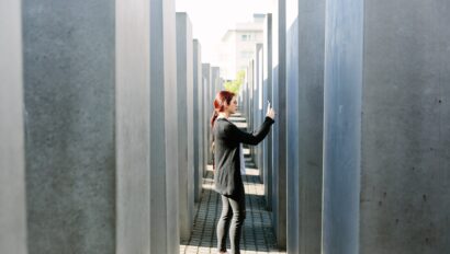 A woman takes a photo while exploring the Memorial to the Murdered Jews of Europe in Berlin, Germany