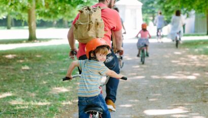 A father and son ride a tandem bike through Versailles, France