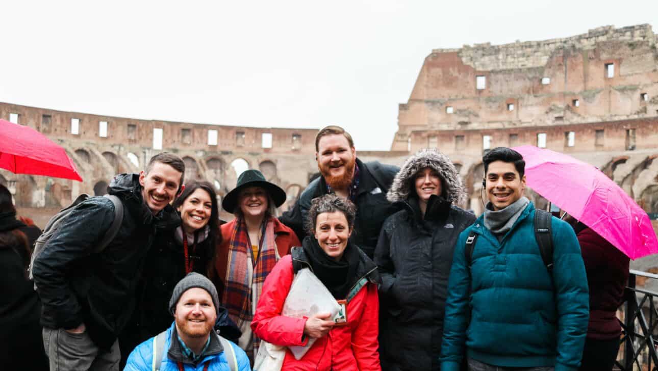 A group poses for a photo inside the Colosseum in Rome, Italy