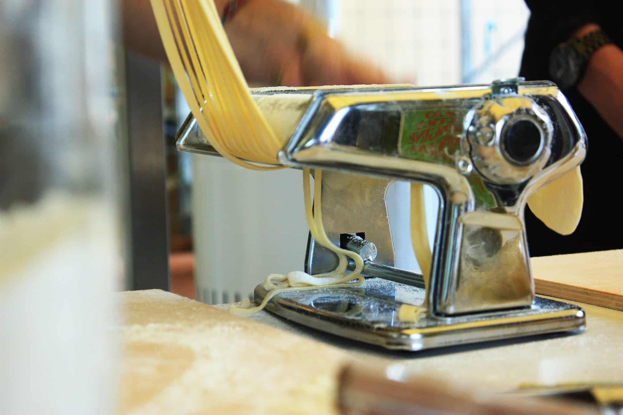 Pasta is pulled through a machine in Rome, Italy