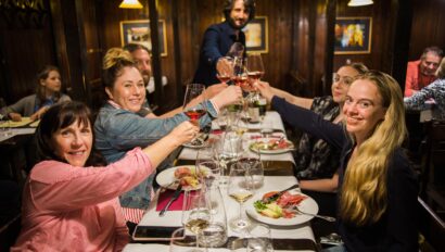A group cheers glasses at a wine tasting in Rome, Italy
