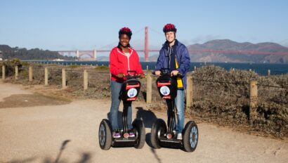 Two people ride Segways in front of the Golden Gate Bridge in San Francisco, California