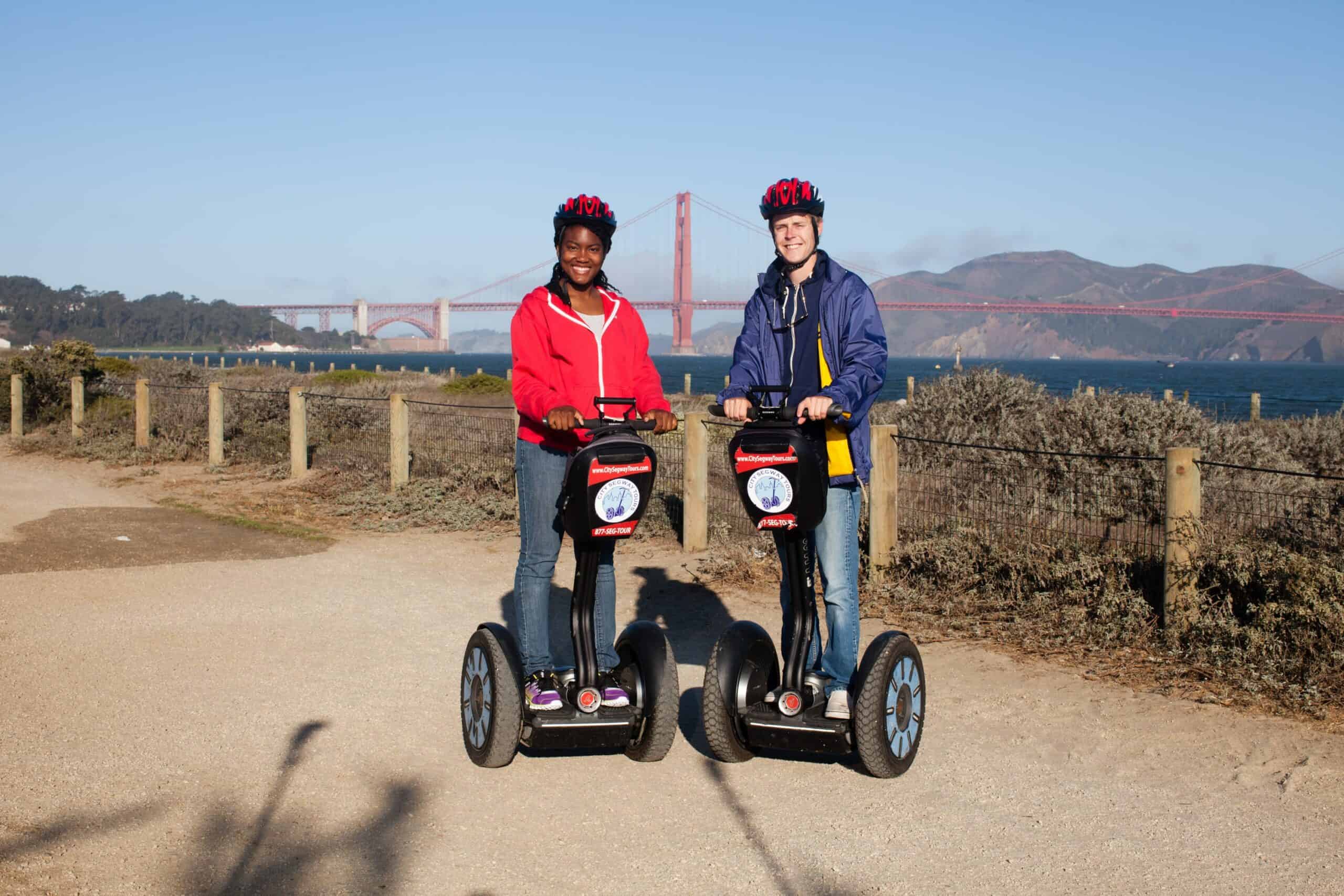 Two people ride Segways in front of the Golden Gate Bridge in San Francisco, California