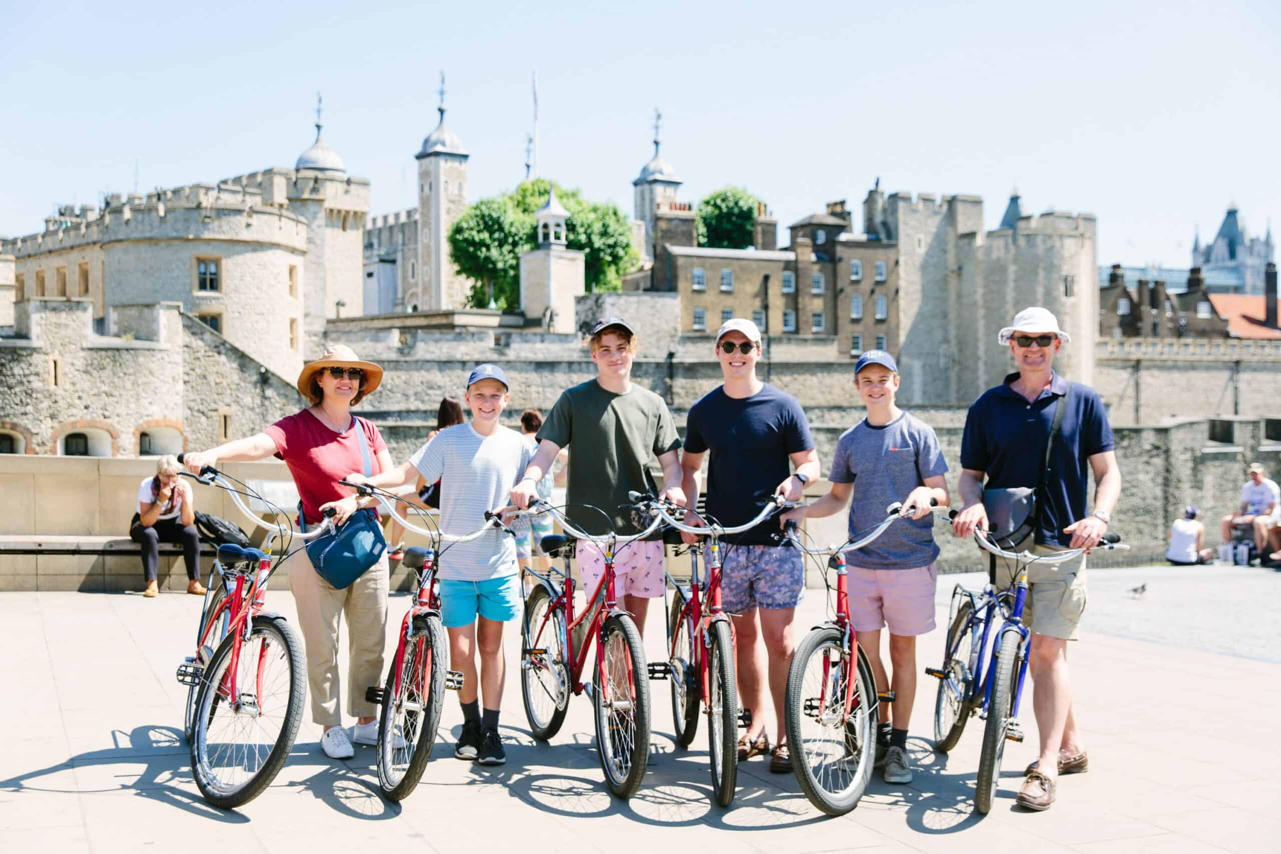 A group poses with their bikes in front of the Tower of London