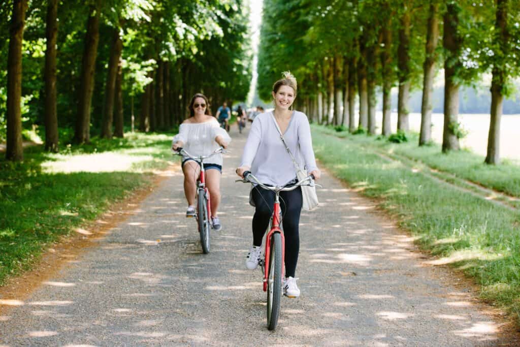 women smiling and riding around the Grand Canal in Versailles, France