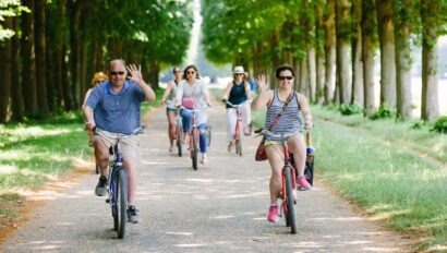 A group waves as they ride through the Gardens of Versailles