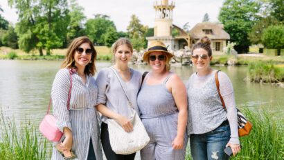 A group of women pose in front of Marie Antoinette's Hamlet in Versailles, France