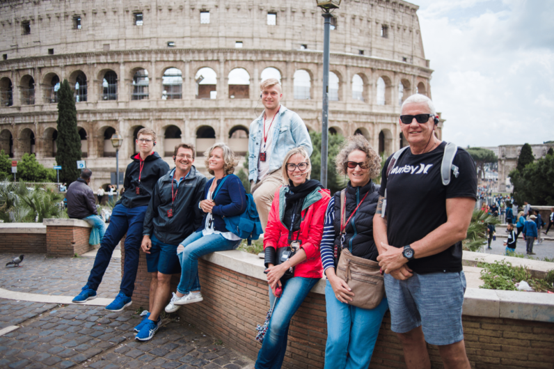 A group of people pose for a photo outside the Colosseum