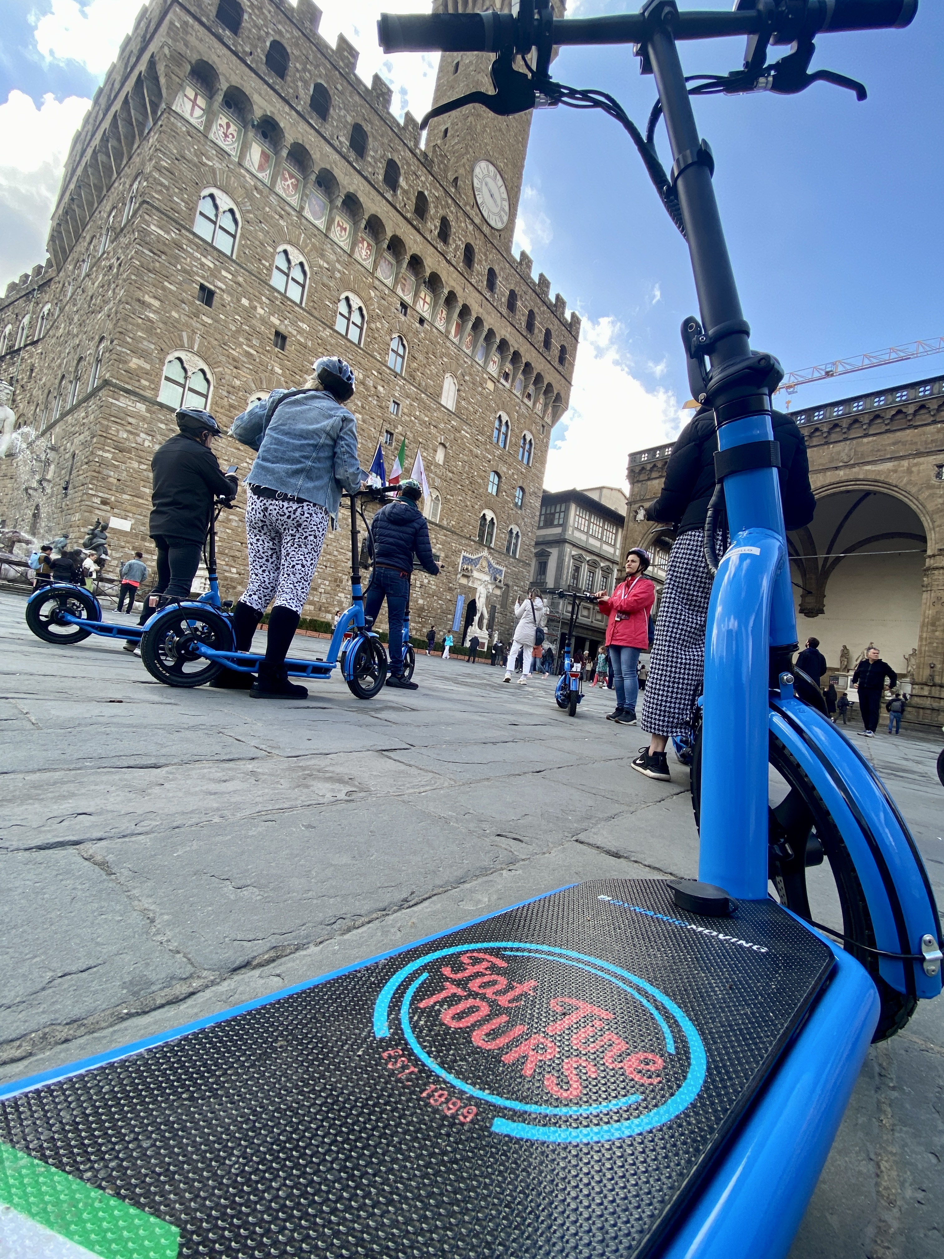 A group of e-scooter riders learn about the Piazza Signoria in Florence, Italy