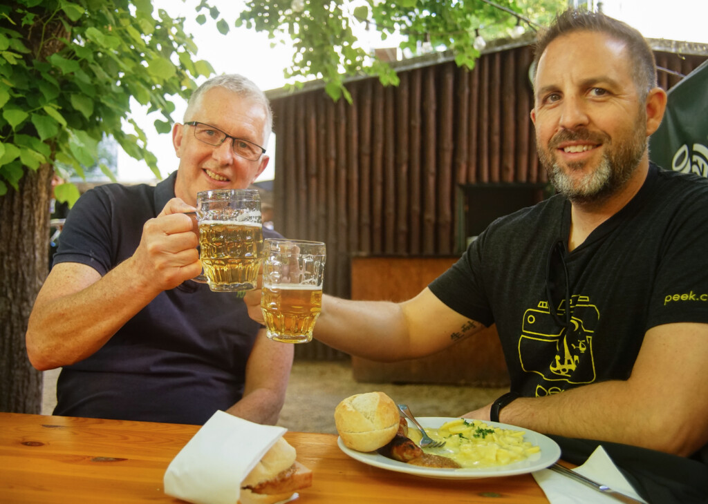 Two friends enjoy a beer and traditional German food at a beer garden in Berlin