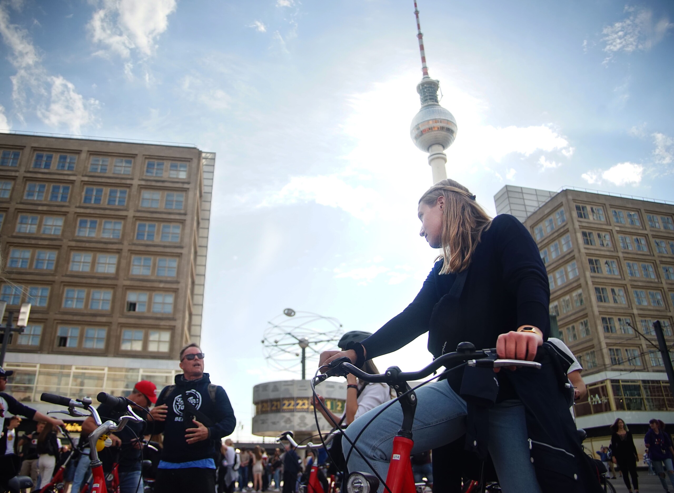 A woman listens to the guide in Alexanderplatz near the Welteituhr monument