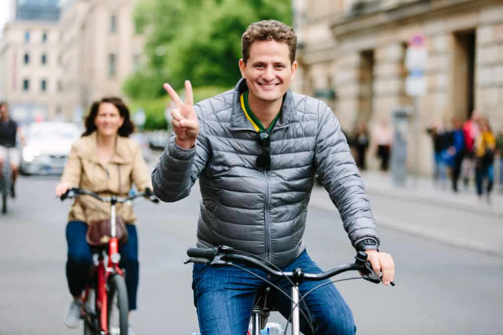 A person on a bike showing a peace sign.