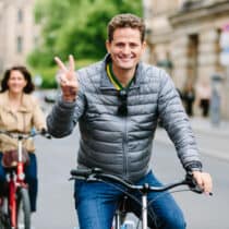 A person on a bike showing a peace sign.