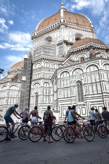 A group of cyclists pauses to admire the Duomo in Florence, Italy