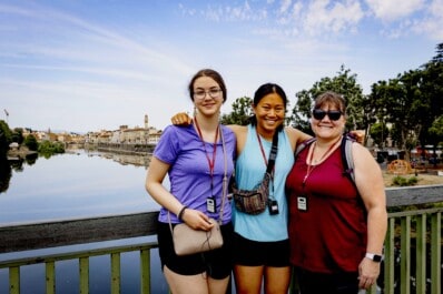 A group of friends poses for a photo on a bridge in Florence, Italy