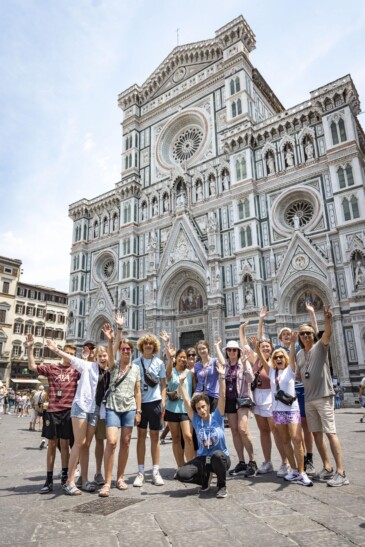 A group poses for a fun photo in front of the Duomo in Florence, Italy