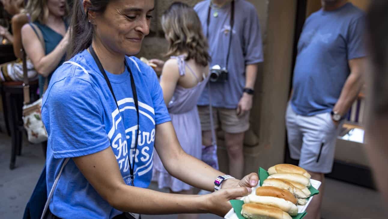 A guide holds out truffle sandwiches for the group to try