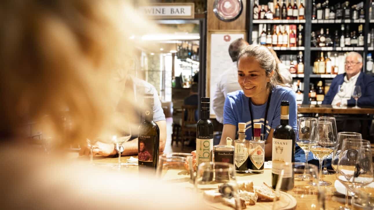 The guide smiles and chats with the group during a Florence wine tasting