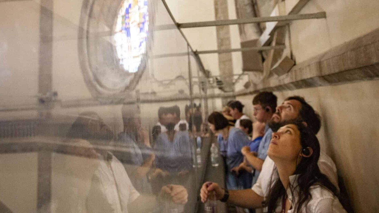 A group walks around the edge of the interior dome inside the Florence cathedral