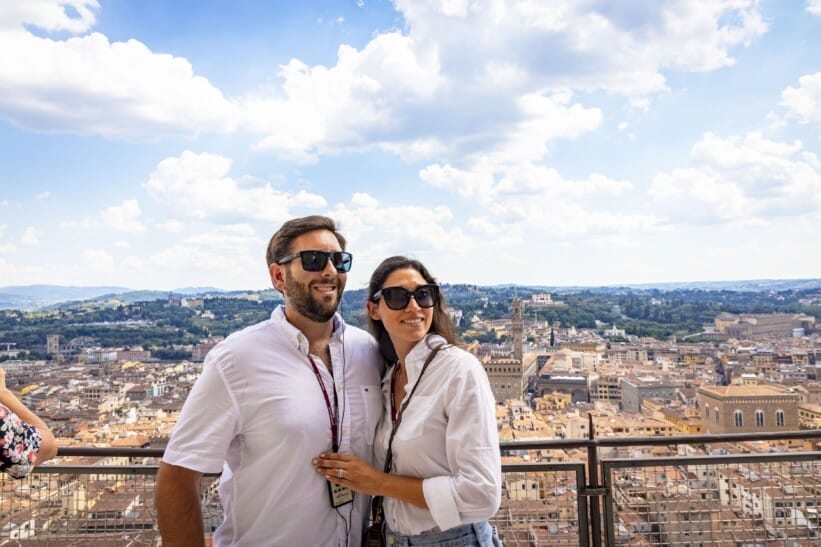 A couple poses for a photo on top of the Florence Cathedral