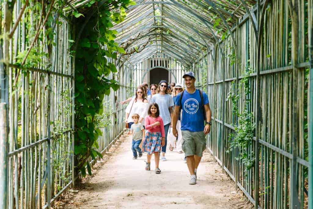 A guide walks with his group through the grounds of Versailles