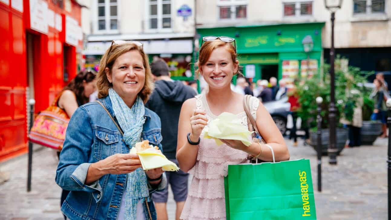 Two women enjoy a snack in the Marais in Paris, France