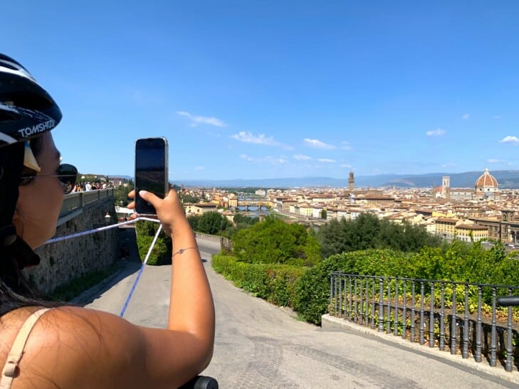 a woman takes a photo from piazzale michelangelo in Florence, Italy
