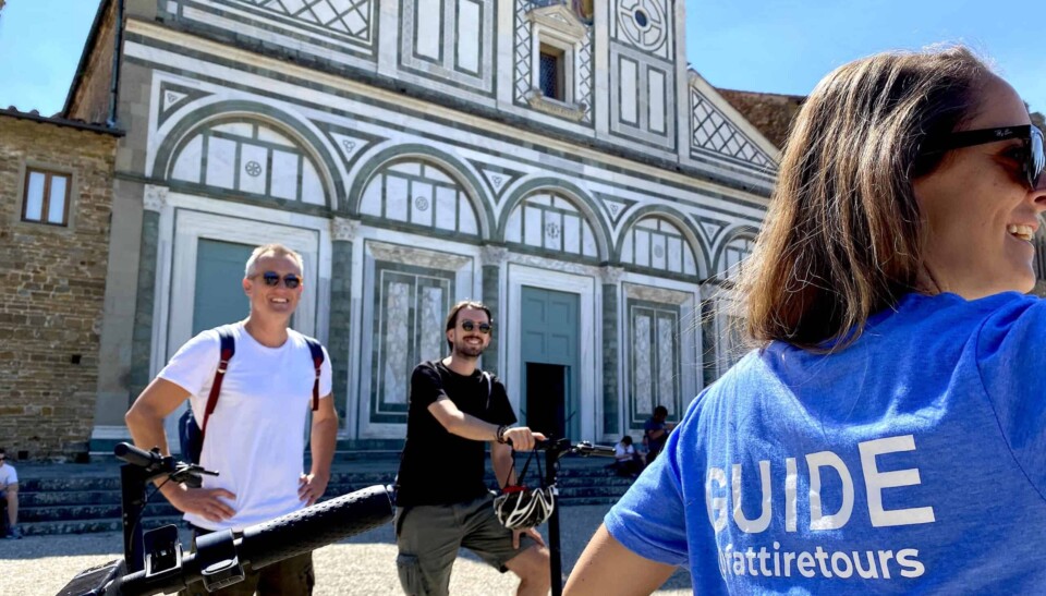 a group on e-scooters gathers in front of the San Miniato church in Florence, Italy