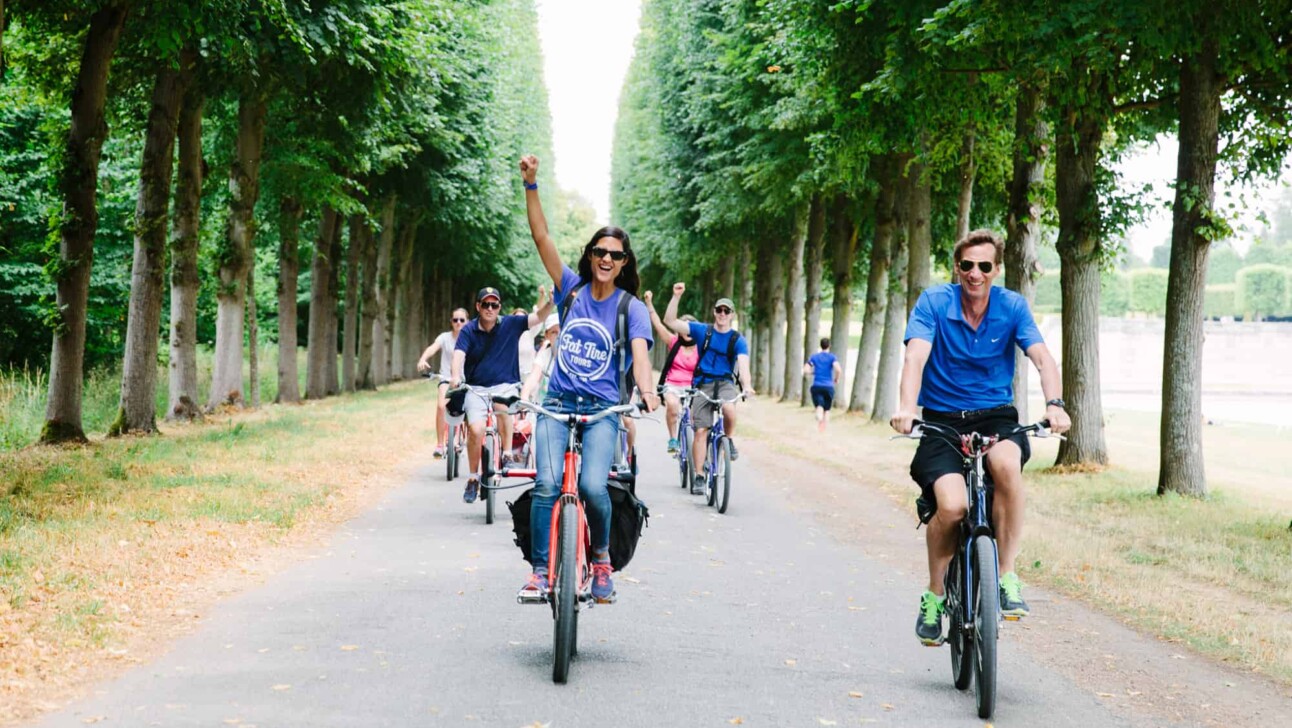a group of cyclists ride through Versailles