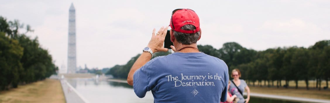 A man takes a picture of the Washington Monument