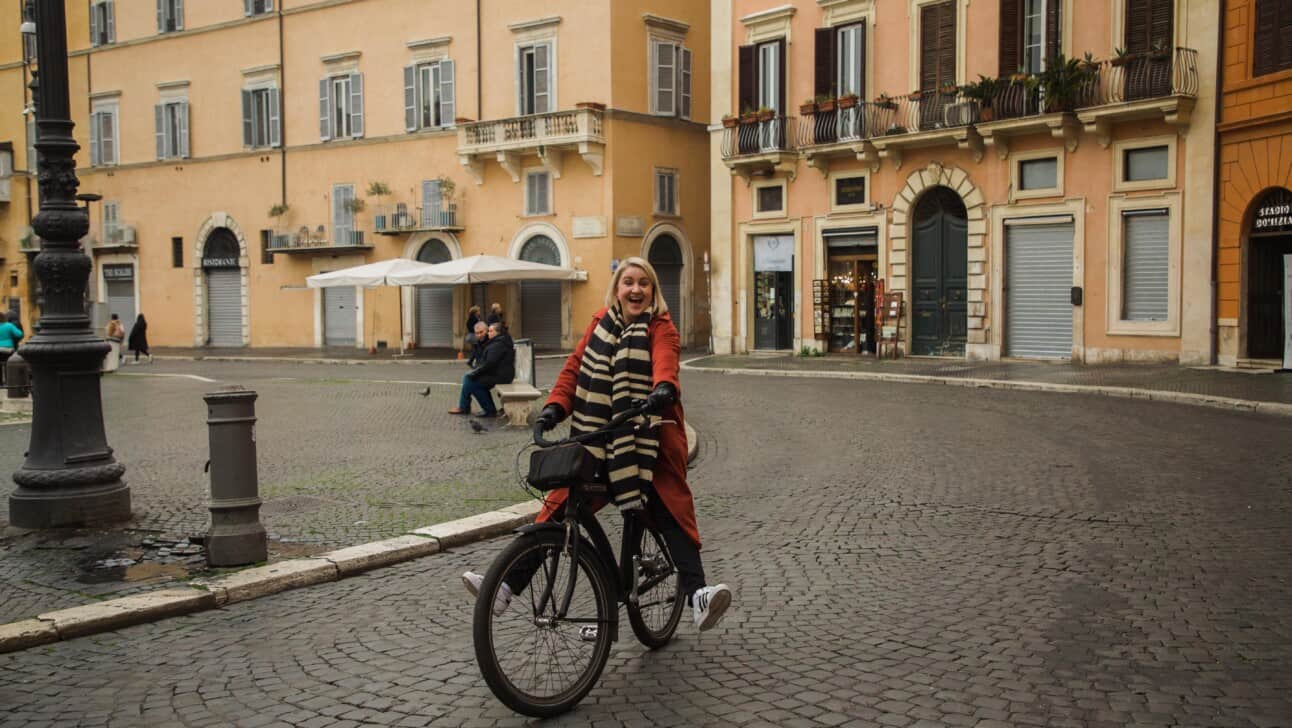 A woman rides her bike through Piazza Navona in Rome, Italy