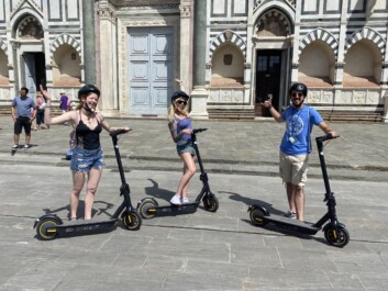 A group on e-scooters stops for a photo in front of the Florence Duomo