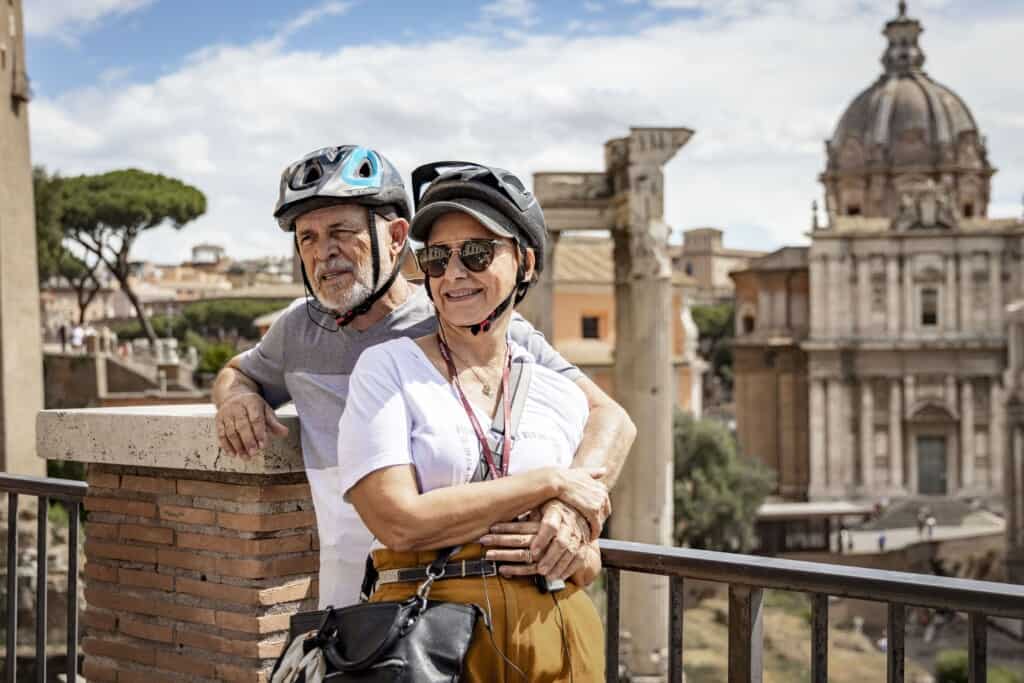 A couple with their arms around each other listen intently to the guide during a Segway Tour in Rome