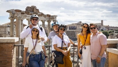 A group of Segwayers pose for a photo looking out over the city of Rome, Italy