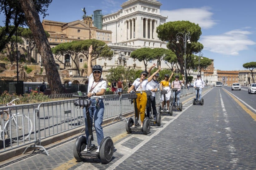 A group of people ride through Rome on Segways
