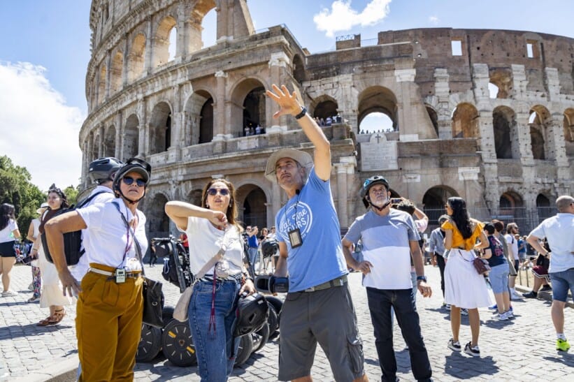 A Segway group stops in front of the Colosseum in Rome, Italy