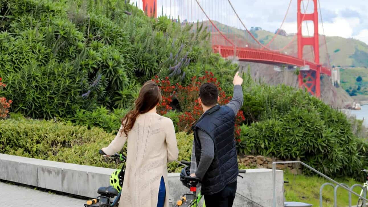 A couple looks on towards the Golden Gate Bridge in San Francisco, California