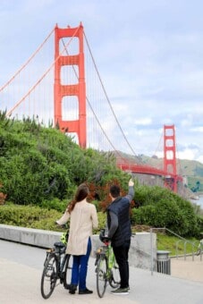 A couple looks on towards the Golden Gate Bridge in San Francisco, California