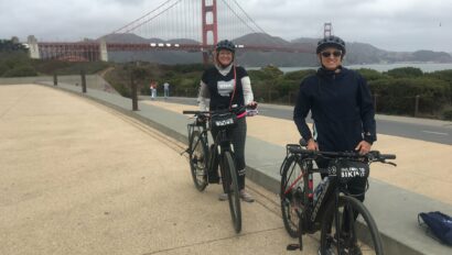 A couple poses with their bikes in front of the Golden Gate Bridge in San Francisco, California