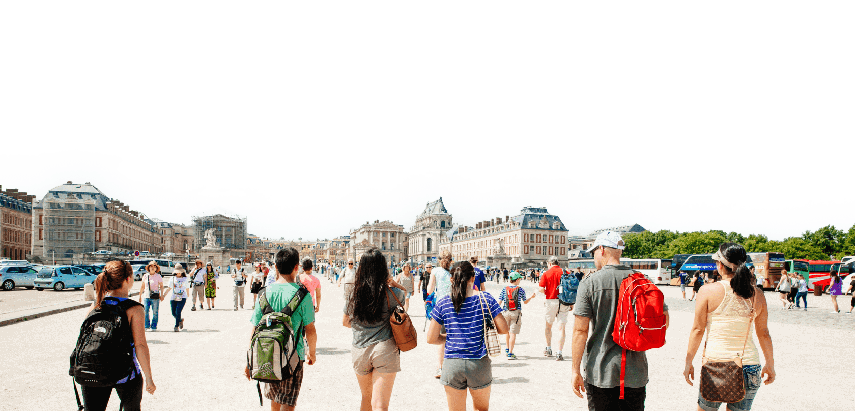 A group of people walk towards the Versailles Chateau