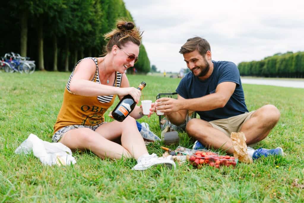 A couple enjoys a glass of bubbly along the Grand Canal in Versailles