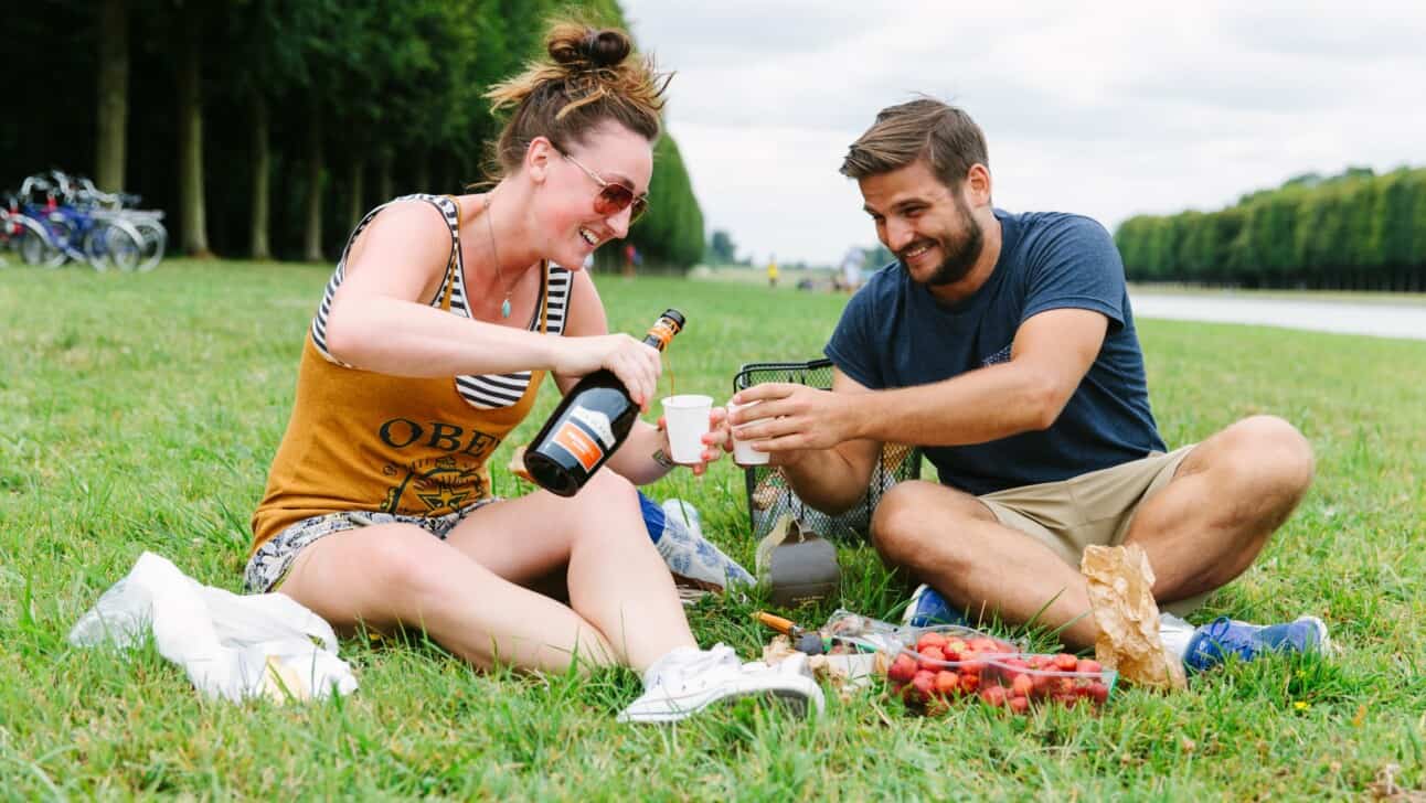 A couple enjoys a glass of bubbly along the Grand Canal in Versailles