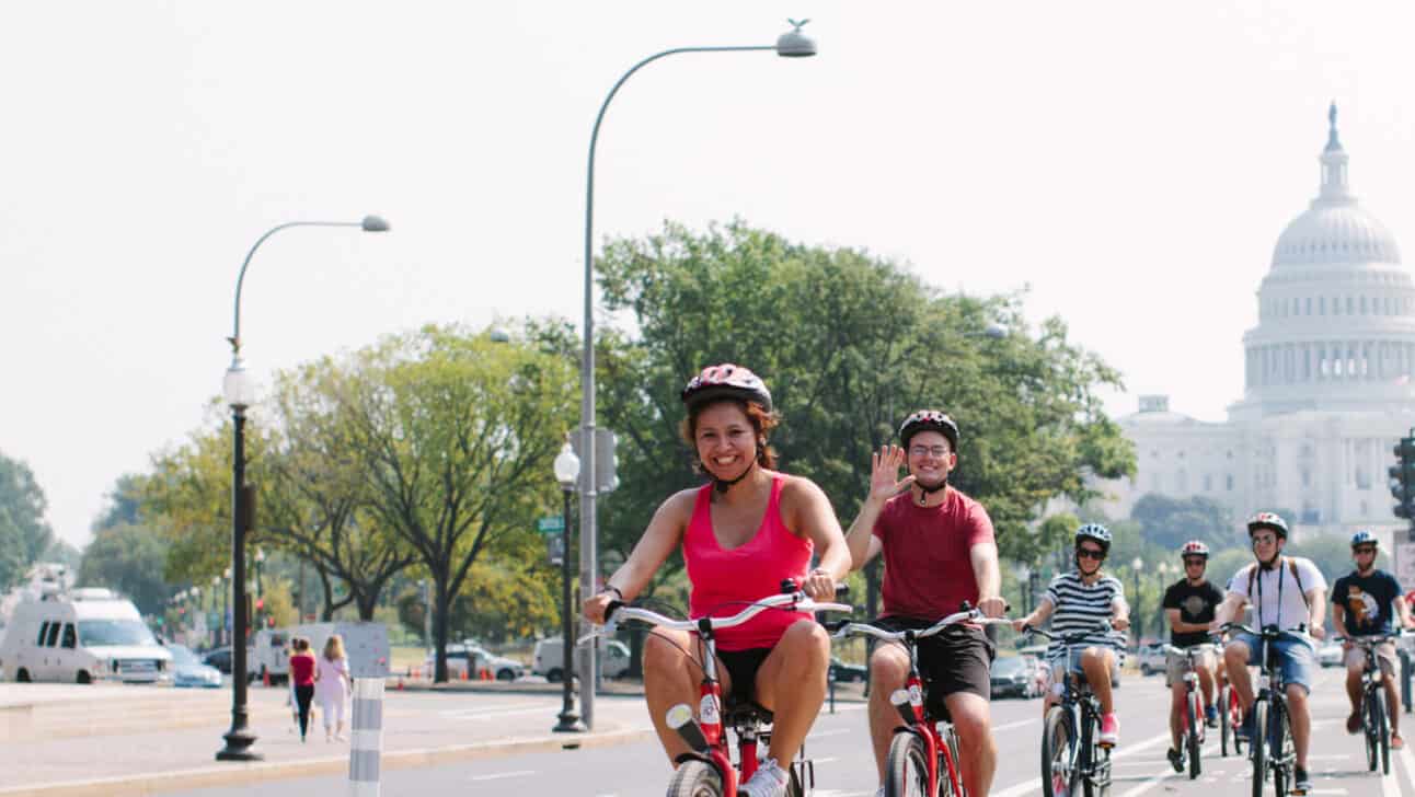 A group of cyclists ride down Pennsylvania Avenue in front of the US Capitol Building