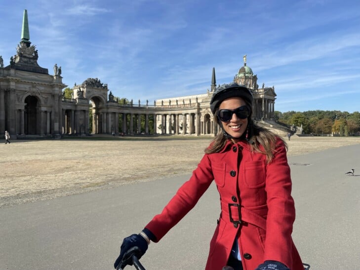 A woman in a red coat on her bicycle in Potsdam