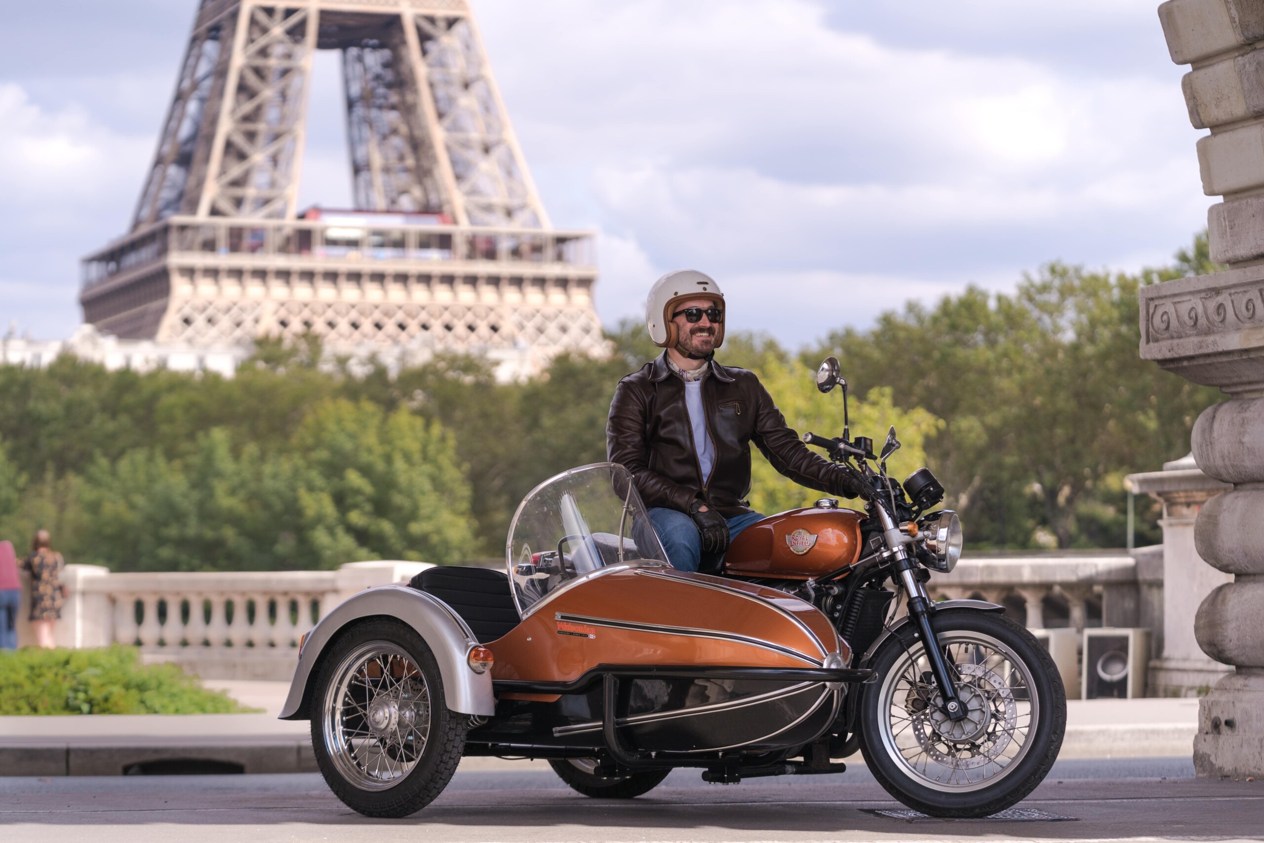 A motorcycle with a sidecar in front of the Eiffel Tower