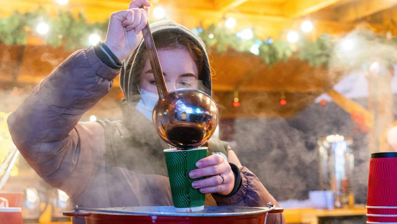 A woman serves hot glühwein at a Berlin Christmas Market
