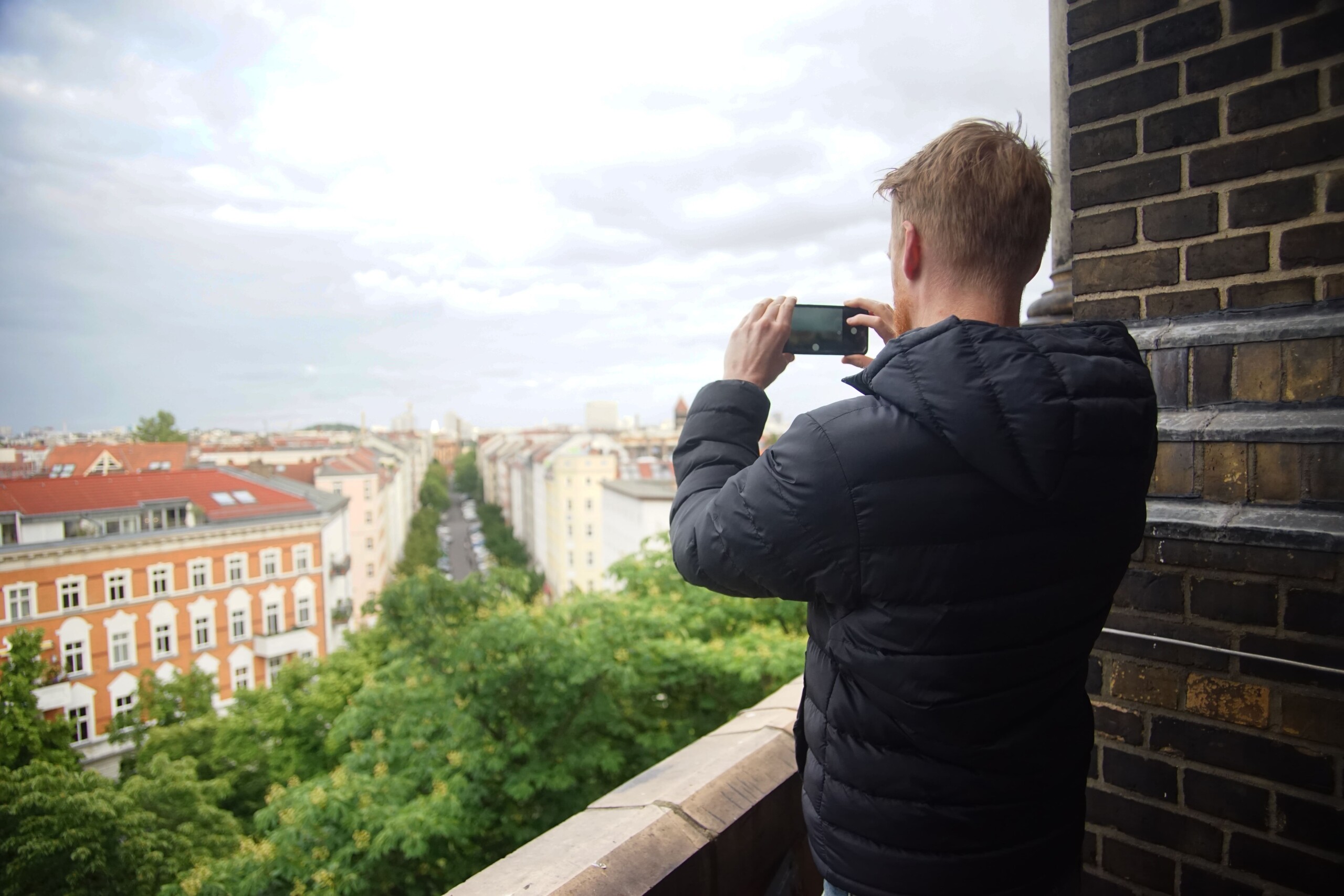 A man takes a photo from the top of the Zionskirche church in Berlin, Germany