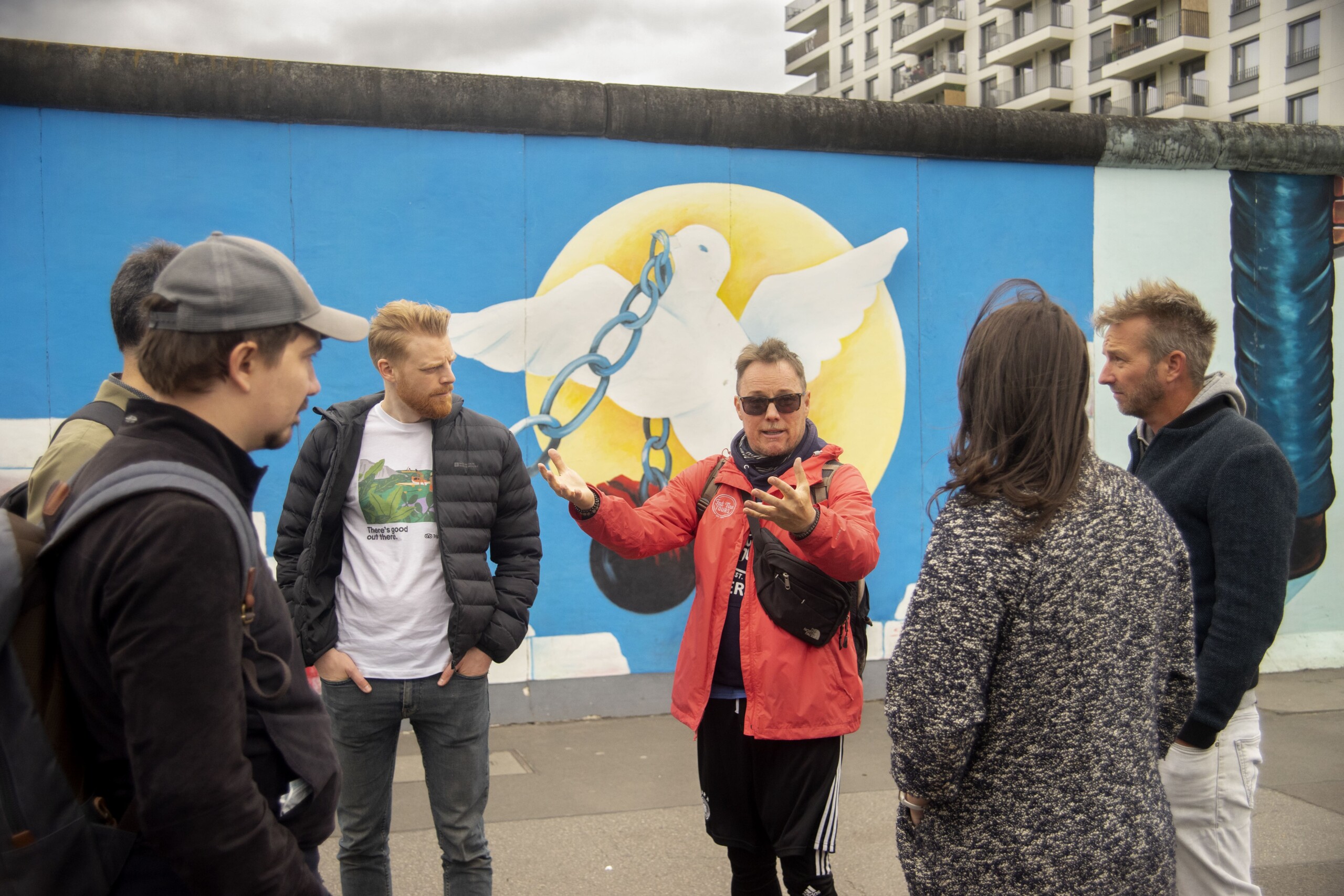 The guides explains the significance of the East Side Gallery in Berlin, Germany